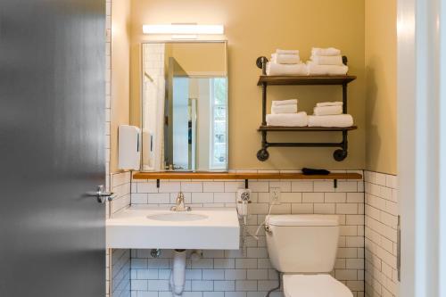 a bathroom with a sink and a toilet and a mirror at HI New Orleans Hostel in New Orleans