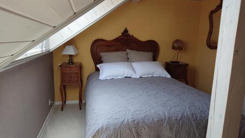 sypialnia z łóżkiem z drewnianym zagłówkiem w obiekcie GITE DU CLOS PAISIBLE w mieście Jebsheim