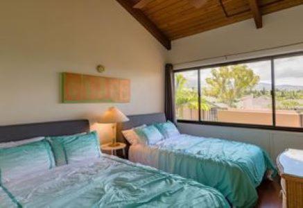 a bedroom with two beds and a large window at Kamaole Sands 4-410 in Wailea
