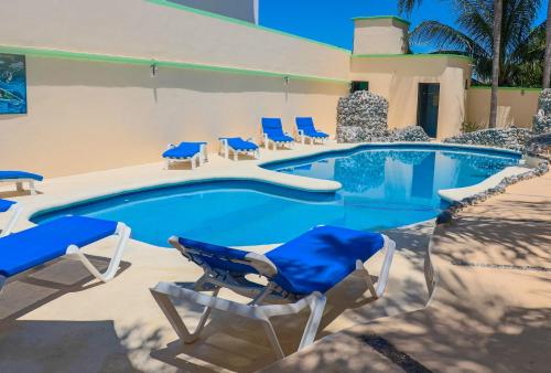 a swimming pool with blue chairs and a swimming pool at Villas Coco Resort - All Suites in Isla Mujeres