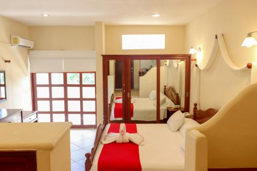 a bedroom with a bed with a red blanket at Villas Coco Resort - All Suites in Isla Mujeres