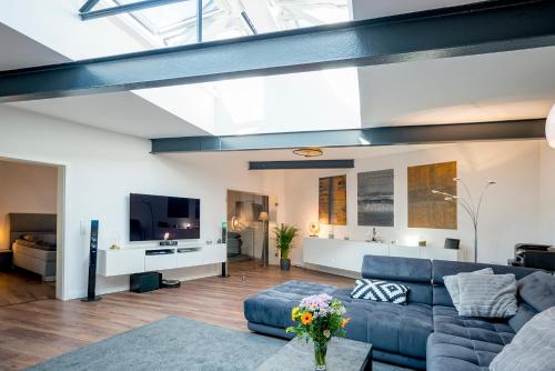a living room with a blue couch and a tv at White Lofty und White Studio in Düsseldorf