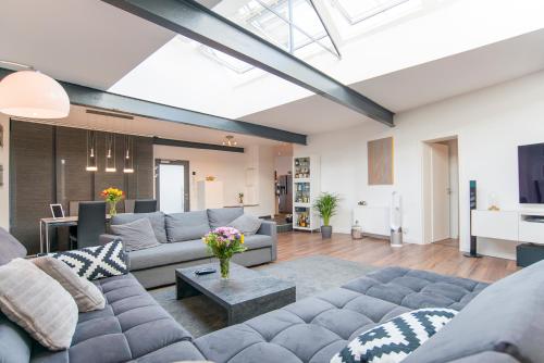 a living room with a couch and a table at White Lofty und White Studio in Düsseldorf