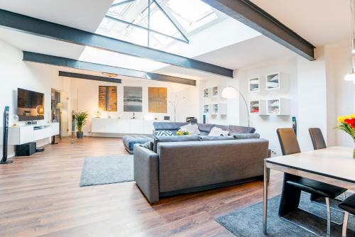 a living room with a couch and a table at White Lofty und White Studio in Düsseldorf