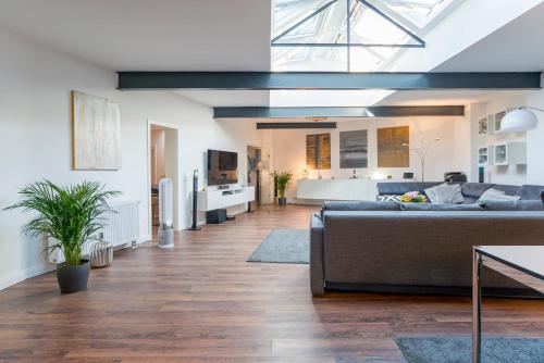 a living room with a couch and a kitchen at White Lofty und White Studio in Düsseldorf