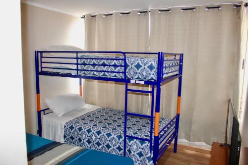 a blue bunk bed in a room with a bed at Departamento Jardines de Huayquique in Iquique