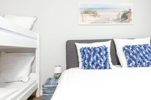 Schlafzimmer mit einem Bett mit blauen und weißen Kissen in der Unterkunft NIZZA CHILLINGHOUSE #1, 3 Min vom ICE, NETFLIX, Balkon in Siegburg