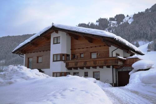 a building with snow on the roof of it at Gästehaus Sonja in Niederau