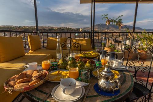 una mesa con comida y pan en el balcón en Riad Dar Tahri, en Fez
