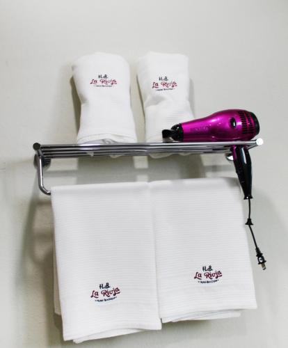 a towel rack with towels and a bottle of wine at Hotel Boutique La Rioja in Atlixco
