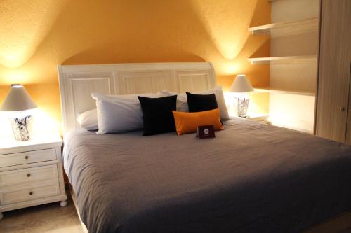 a bedroom with a bed with two lamps and a clock on it at Hotel Boutique La Rioja in Atlixco