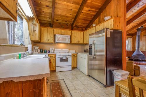 a kitchen with wooden cabinets and a stainless steel refrigerator at Bear's Den in Idyllwild
