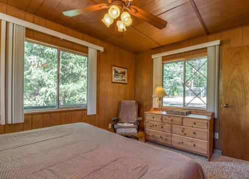 a bedroom with a bed and a dresser and windows at Bear's Den in Idyllwild
