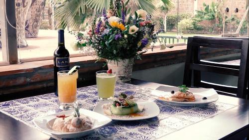 a table with two plates of food and a bottle of wine at Hotel Boutique La Rioja in Atlixco