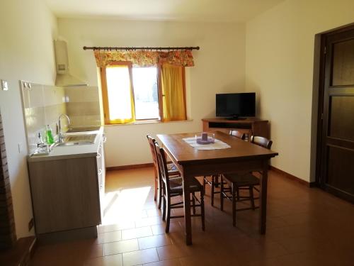 a kitchen with a table and chairs and a kitchen with a sink at La Lanterna di Lanfo in Assisi