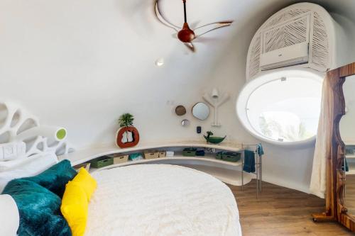 a bedroom with a bed and a large window at Seahorse @ Swan Villas in Placencia Village
