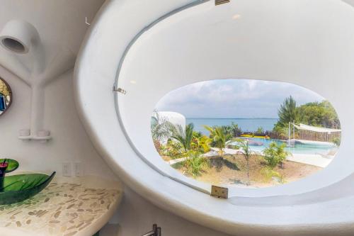 a mirror in a bathroom with a view of the ocean at Seahorse @ Swan Villas in Placencia Village