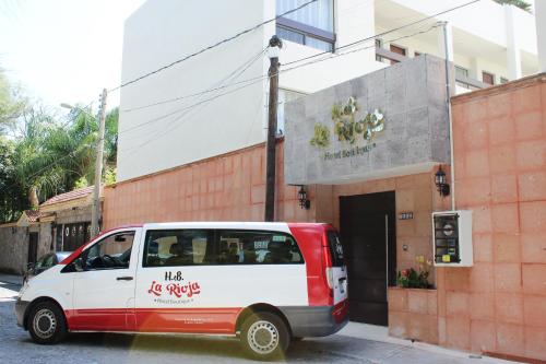 a red and white van parked in front of a building at Hotel Boutique La Rioja in Atlixco