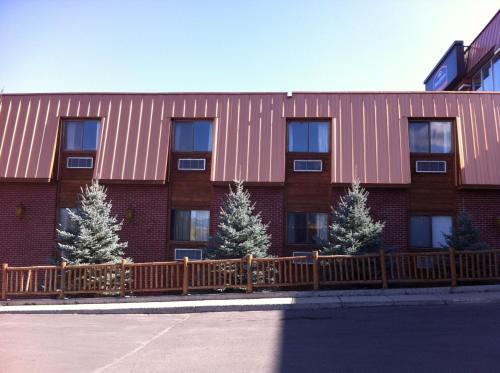 a red brick building with trees in front of it at Longhorn Hotel in Helena