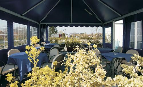 a restaurant with blue tables and chairs and plants at Hotel Persico's in San Giovanni in Persiceto