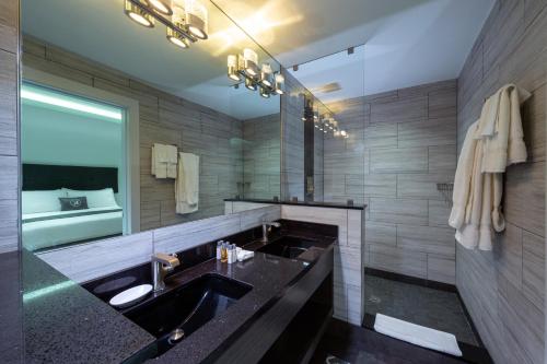 a bathroom with a sink and a large mirror at Kent Hotel in Miami Beach