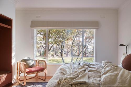 a bedroom with a bed and a large window at Polperro Farmhouse in Red Hill