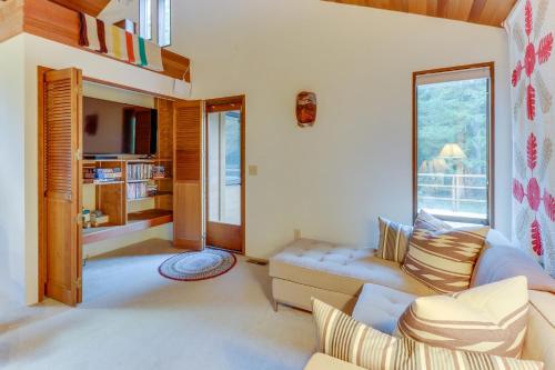 a living room with a couch and a large window at Sleeping Raven Woodland Retreat in Port Angeles