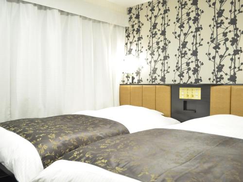 Postel nebo postele na pokoji v ubytování APA Hotel Okayama Ekimae