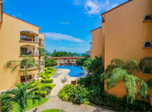 an aerial view of a resort with a pool and palm trees at Sunrise 22 in Tamarindo