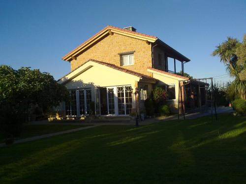 a large brick house with a lawn in front of it at Casa Los Abetos in Quintueles