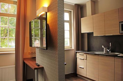 a kitchen with a sink and a mirror on the wall at Apart Neptun in Gdańsk