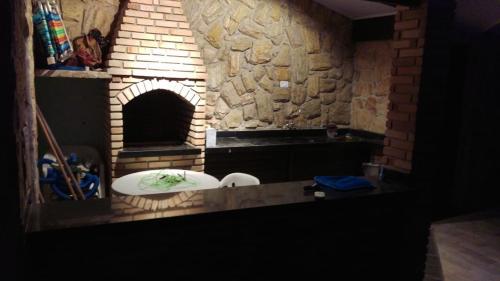 a brick oven with a stone wall in a room at Meu Paraíso! in Boracéia