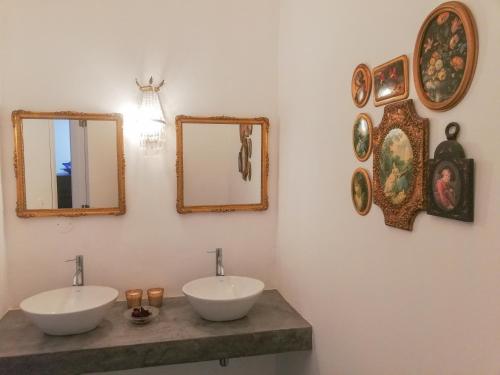 a bathroom with two sinks and mirrors on the wall at Casa Brazao Mira in Casa Branca