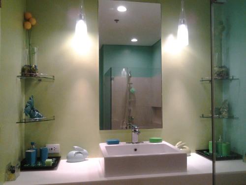 a bathroom with a sink and a large mirror at Lagoon view Family Suite in Pico De Loro Cove, Nasugbu in Nasugbu