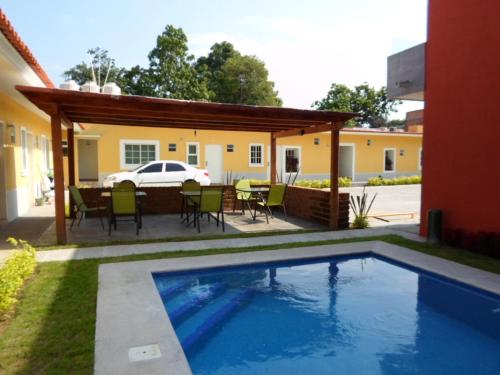 a swimming pool in the yard of a house at Hotel Montroi City in Colima