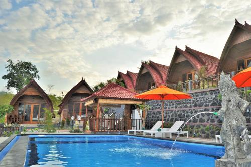 a villa with a swimming pool in front of a house at Surya Chandra Beach Bungalow in Nusa Penida