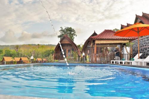 a pool with a water fountain in front of a house at Surya Chandra Beach Bungalow in Nusa Penida