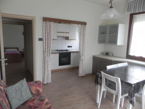 a kitchen and living room with a table and chairs at Casa Ferrari Michela in Calceranica al Lago