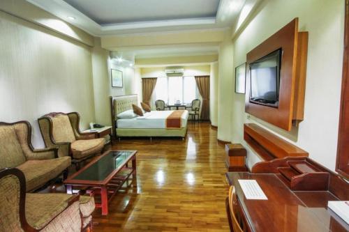 a hotel room with a bed and a living room at Grand Menteng Hotel in Jakarta