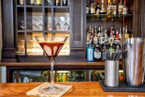 a drink in a martini glass sitting on a table at Nugget Point Hotel in Queenstown