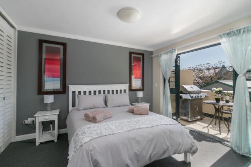 a bedroom with a large bed and a balcony at Blue Moon Apartments in Knysna