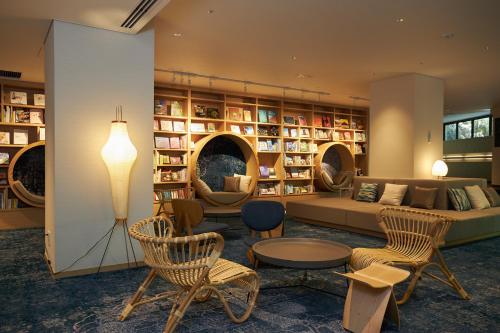 a living room with a couch and chairs and bookshelves at Hakone Yutowa in Hakone