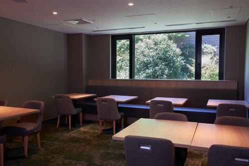 a classroom with tables and chairs and a large window at Hakone Yutowa in Hakone