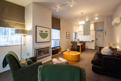 a living room with a couch and a fireplace at Kent Street Apartments - Element Escapes in Queenstown