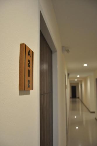 a door sign on a wall in a hallway at My Room in Ratchaburi