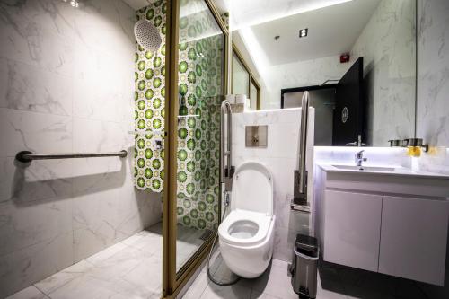 a bathroom with a toilet and a shower and a sink at CUBE Boutique Capsule Hotel at Kampong Glam in Singapore