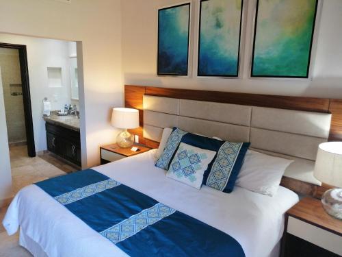 a bedroom with a bed with blue and white pillows at Luxury Suites By Estrella del Mar in Mazatlán