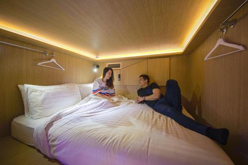 
a woman laying on top of a bed in a bedroom at CUBE Boutique Capsule Hotel @ Kampong Glam (SG Clean) in Singapore

