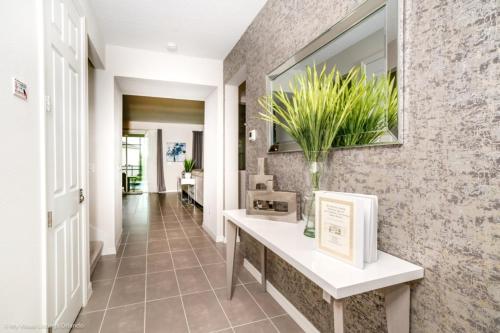 einen Flur eines Hauses mit einem Waschbecken und einem Spiegel in der Unterkunft 1719Cvt Orlando Newest Resort Community Home Villa in Orlando