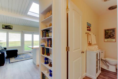 a bathroom with a toilet and a book shelf at Surfside | Suite on the Sea in Gearhart